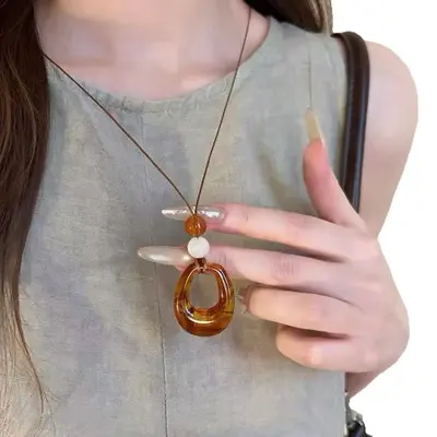 Round ring pendant necklace, black cord, long chain style