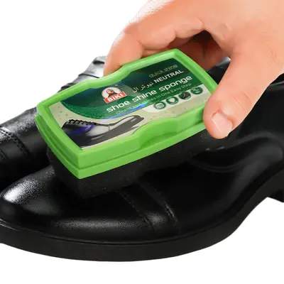 Farbloses Lederpflegeöl und schwarze Schuhcreme mit Schwammbürste