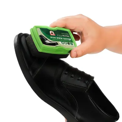 Farbloses Lederpflegeöl und schwarze Schuhcreme mit Schwammbürste